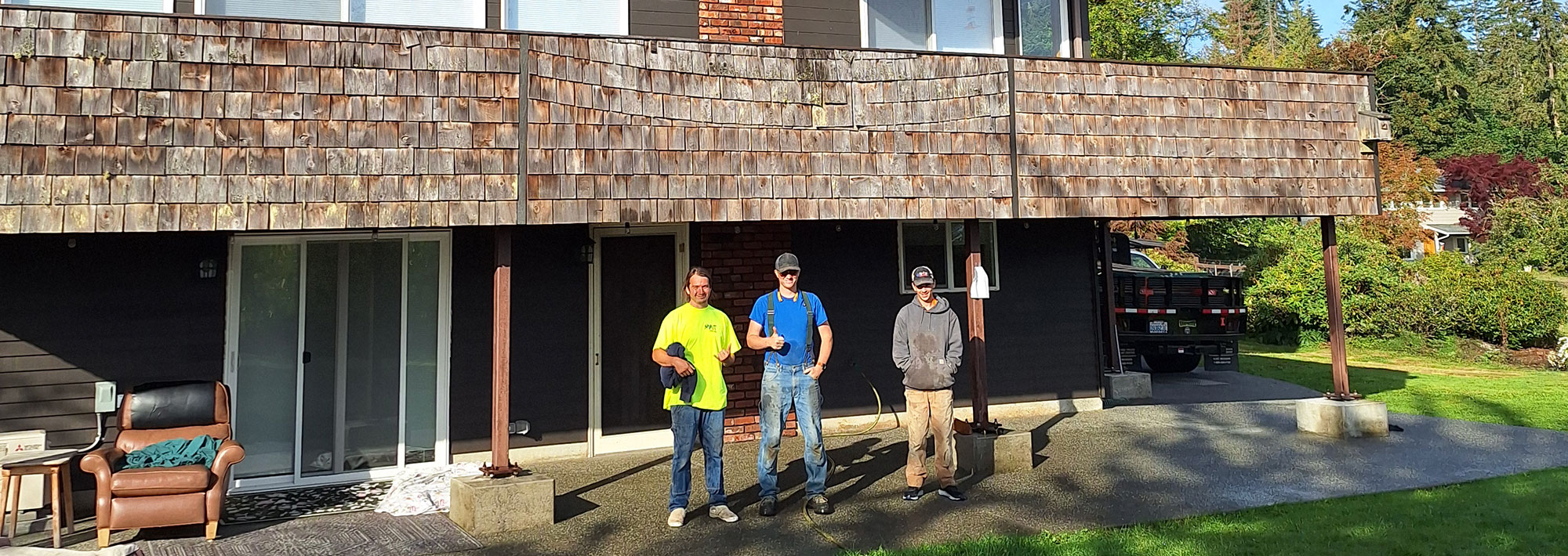 house with three workmen standing in front